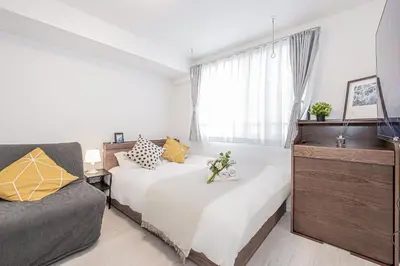 a bedroom with two beds and a couch at \u65b0\u5bbf16 Shinjuku16 in Tokyo