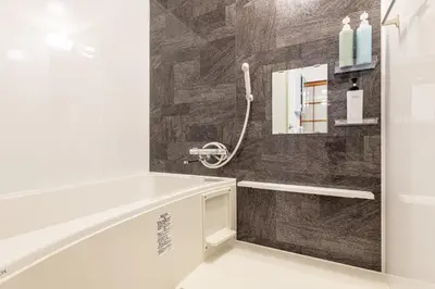a bathroom with a bath tub and a mirror at \u5409\u623f\u6c11\u5bbf YOSHIFUSA House \u6674\u7a7a\u5854\u5f92\u6b65\u5708 \u6574\u680b\u51fa\u79df in Tokyo