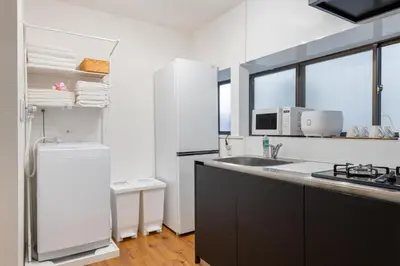 a kitchen with a sink and a refrigerator at \u5409\u623f\u6c11\u5bbf YOSHIFUSA House \u6674\u7a7a\u5854\u5f92\u6b65\u5708 \u6574\u680b\u51fa\u79df in Tokyo