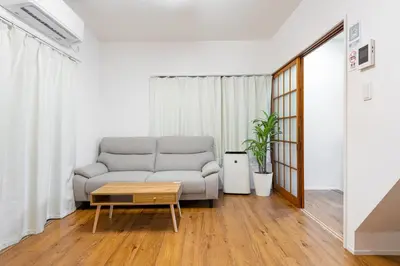 a living room with a couch and a coffee table at \u5409\u623f\u6c11\u5bbf YOSHIFUSA House \u6674\u7a7a\u5854\u5f92\u6b65\u5708 \u6574\u680b\u51fa\u79df in Tokyo