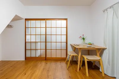 a room with a table and two chairs and a door at \u5409\u623f\u6c11\u5bbf YOSHIFUSA House \u6674\u7a7a\u5854\u5f92\u6b65\u5708 \u6574\u680b\u51fa\u79df in Tokyo