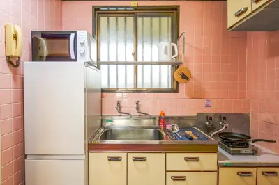 a kitchen with a sink and a white refrigerator at Near Shinjyuku hostel in Tokyo