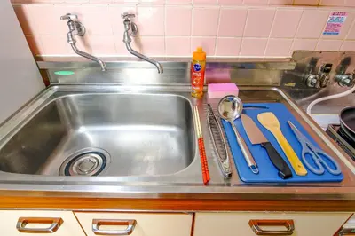 a kitchen sink with scissors and a cutting board at Near Shinjyuku hostel in Tokyo