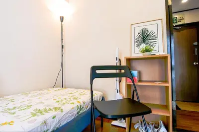 a room with a bed and a chair next to a desk at Near Shinjyuku hostel in Tokyo