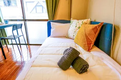 a bed with pillows on it in a room at Near Shinjyuku hostel in Tokyo