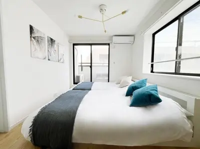 a bedroom with a large bed with blue pillows at tnw\u5357\u9577\u5d0e3\u4e01\u76ee in Tokyo