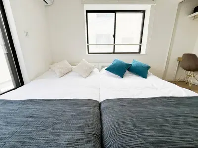 a bedroom with two beds with blue pillows at tnw\u5357\u9577\u5d0e3\u4e01\u76ee in Tokyo