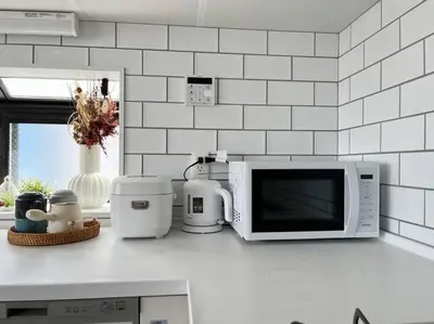 a kitchen counter with a microwave and appliances on it at tnw\u5357\u9577\u5d0e3\u4e01\u76ee in Tokyo