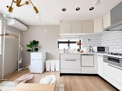 a kitchen with white cabinets and a white refrigerator at tnw\u5357\u9577\u5d0e3\u4e01\u76ee in Tokyo