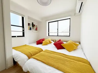 two beds in a room with two windows at tnw\u5357\u9577\u5d0e3\u4e01\u76ee in Tokyo