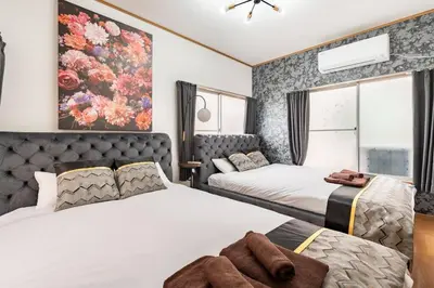 a bedroom with two beds and a painting on the wall at \u67f4\u53c81\u4e01\u76ee in Tokyo