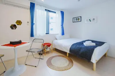 a bedroom with a bed and a table and a chair at QH101, Newly renovated hotel, direct access to Ueno, Asakusa, Disneyland, Airport, in Tokyo
