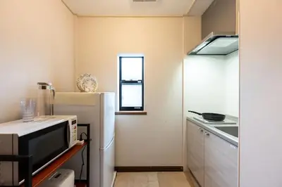 a small kitchen with a refrigerator and a window at YJ-HOTEL kamiikebukuro 3F \u5317\u6c60\u888b5\u5206\u949f \u65b0\u88c5\u4e0a\u7ebf 61\u5e73\u65b9 in Tokyo