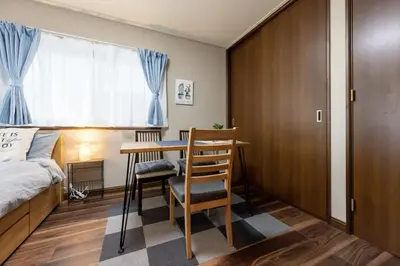 a bedroom with a desk and a bed and a bedroom with blue curtains at YJ-HOTEL kamiikebukuro 3F \u5317\u6c60\u888b5\u5206\u949f \u65b0\u88c5\u4e0a\u7ebf 61\u5e73\u65b9 in Tokyo
