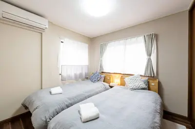 two beds in a room with two windows at YJ-HOTEL kamiikebukuro 3F \u5317\u6c60\u888b5\u5206\u949f \u65b0\u88c5\u4e0a\u7ebf 61\u5e73\u65b9 in Tokyo