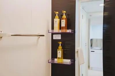 a bathroom with three bottles of alcohol on shelves at QH102, Newly renovated hotel, direct access to Ueno, Asakusa, Disneyland, Airport in Tokyo