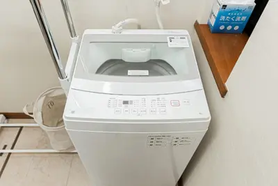 a washing machine sitting on the floor next to a wall at YJ-HOTEL kamiikebukuro 1F \u5317\u6c60\u888b5\u5206\u949f \u65b0\u88c5\u4e0a\u7ebf 52\u5e73\u65b9 in Tokyo