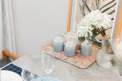 a table with a tray with a vase of flowers and a vase at YJ-HOTEL kamiikebukuro 1F \u5317\u6c60\u888b5\u5206\u949f \u65b0\u88c5\u4e0a\u7ebf 52\u5e73\u65b9 in Tokyo