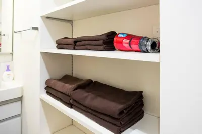 a bathroom with white shelves with brown towels at Kita-Akabane - Diamond Yu in Tokyo