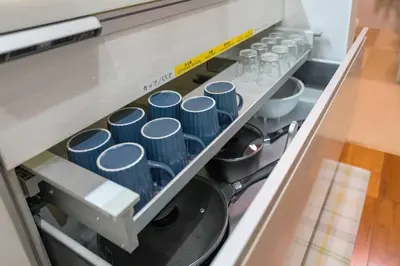 a row of blue dishes on a shelf in a kitchen at Kita-Akabane - Diamond Yu in Tokyo