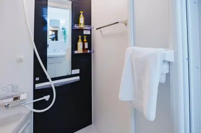 a bathroom with a sink and a shower with towels at QH103, Newly renovated hotel, direct access to Ueno, Asakusa, Disneyland, Airport in Tokyo