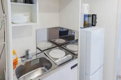 a kitchen with a sink and a refrigerator at QH103, Newly renovated hotel, direct access to Ueno, Asakusa, Disneyland, Airport in Tokyo