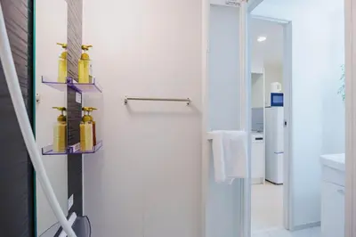 a bathroom with a shower with two shelves at QH103, Newly renovated hotel, direct access to Ueno, Asakusa, Disneyland, Airport in Tokyo