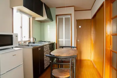 a small kitchen with a table and a microwave at 3\u968e \u5c0f\u5ca9\u99c5\u5f92\u6b6915\u5206 \u53ce\u5bb94\u4eba \u6210\u7530\u7fbd\u7530\u304b\u3089\u30d0\u30b9\u76f4\u901a in Tokyo