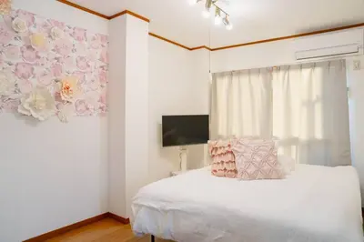 a bedroom with a white bed with a flower painting on the wall at 3\u968e \u5c0f\u5ca9\u99c5\u5f92\u6b6915\u5206 \u53ce\u5bb94\u4eba \u6210\u7530\u7fbd\u7530\u304b\u3089\u30d0\u30b9\u76f4\u901a in Tokyo
