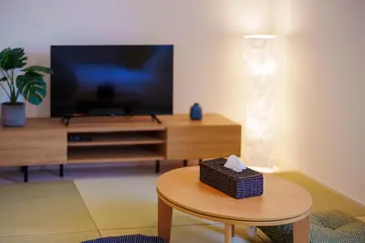 a living room with a table and a tv at QH202, Newly renovated hotel, direct access to Ueno, Asakusa, Disneyland, Airport in Tokyo