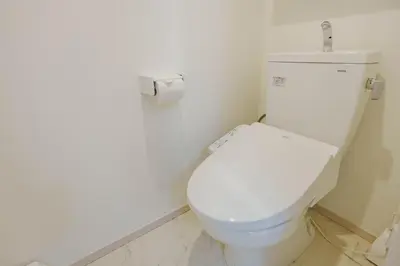 a white toilet in a bathroom with a roll of toilet paper at QH202, Newly renovated hotel, direct access to Ueno, Asakusa, Disneyland, Airport in Tokyo