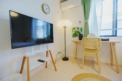 a living room with a large flat screen tv on a wall at QH203, Newly renovated hotel, direct access to Ueno, Asakusa, Disneyland, Airport in Tokyo