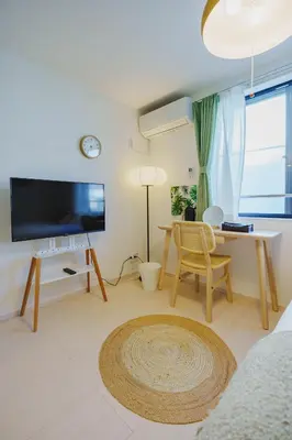 a living room with a flat screen tv and a table at QH203, Newly renovated hotel, direct access to Ueno, Asakusa, Disneyland, Airport in Tokyo