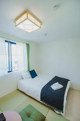 a bedroom with a large white bed with a skylight at QH301, Newly renovated hotel, direct access to Ueno, Asakusa, Disneyland, Airport in Tokyo