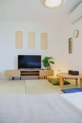 a living room with a television and a table at QH302, Newly renovated hotel, direct access to Ueno, Asakusa, Disneyland, Airport in Tokyo