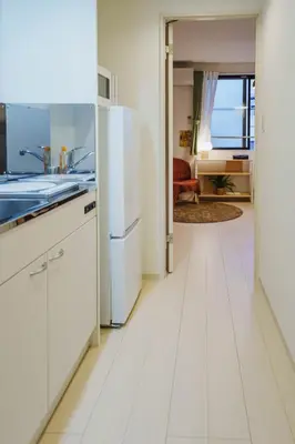 a kitchen with white cabinets and a refrigerator at QH303, Newly renovated hotel, direct access to Ueno, Asakusa, Disneyland, Airport in Tokyo