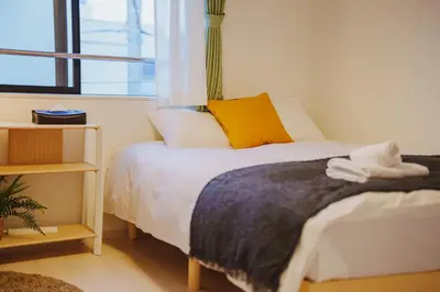 a bedroom with a bed with a cat laying on it at QH303, Newly renovated hotel, direct access to Ueno, Asakusa, Disneyland, Airport in Tokyo