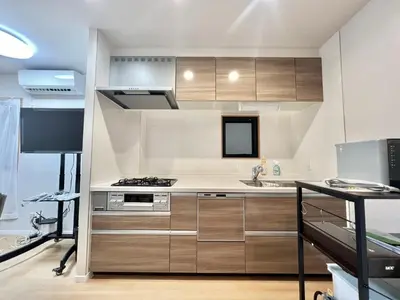 a kitchen with wooden cabinets and a stove top oven at Kenki Torigoe House-TT0173 in Tokyo