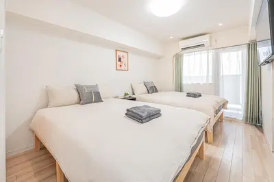 two beds in a room with white walls at \u65b0\u5bbf\u5e02\u4e2d\u5fc3\u6b4c\u821e\u4f0e\u5ba2\u623f\u6e90\u51fa\u884c\u4fbf\u5229\u514d\u8d39Wi-Fi in Tokyo
