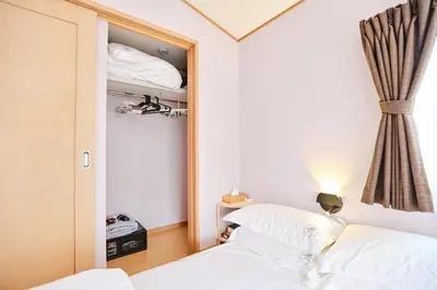 a small bedroom with two beds and a mirror at \u706f\u5149\u65c5\u9928-\u9ad8\u7802 in Tokyo