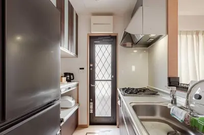 a kitchen with a stainless steel refrigerator and a sink at \u706f\u5149\u65c5\u9928-\u9ad8\u7802 in Tokyo