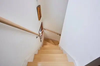 a staircase in a house with a wooden floor and a stair railing at Tsubaki Salon Jujo in Tokyo