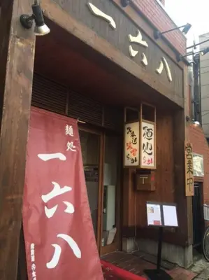a building with a red sign in front of it at Tsubaki Salon Jujo in Tokyo
