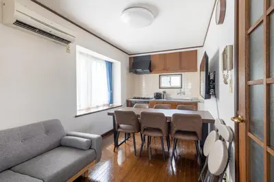 a living room with a couch and a table and chairs at \u30e1\u30be\u30f3\u30c9\u30df\u30ca301 in Tokyo