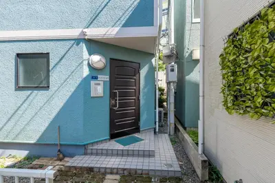 a blue house with a black door next to a building at \u30e1\u30be\u30f3\u30c9\u30df\u30ca301 in Tokyo
