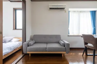 a living room with a chair and a bed at \u30e1\u30be\u30f3\u30c9\u30df\u30ca301 in Tokyo