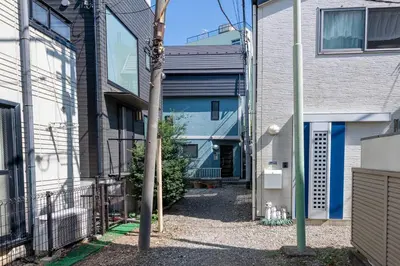 an alley between two buildings with a blue house at \u30e1\u30be\u30f3\u30c9\u30df\u30ca301 in Tokyo