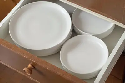 four white bowls in a drawer of a cabinet at \u30e1\u30be\u30f3\u30c9\u30df\u30ca301 in Tokyo