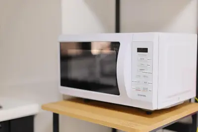 a white microwave sitting on top of a table at Iriya House \u5165\u8c37\u516c\u5bd3 801 in Tokyo