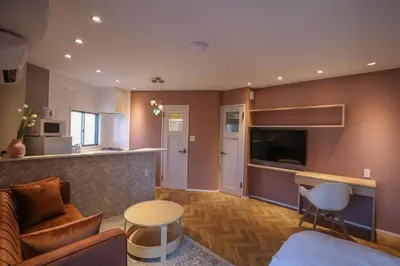 a living room with a couch and a tv and a bar at Shinjuku Waseda Hostel-SJ0147 in Tokyo